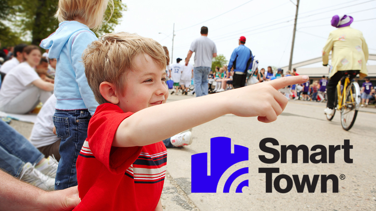 Boy pointing at parade and SmartTown logo