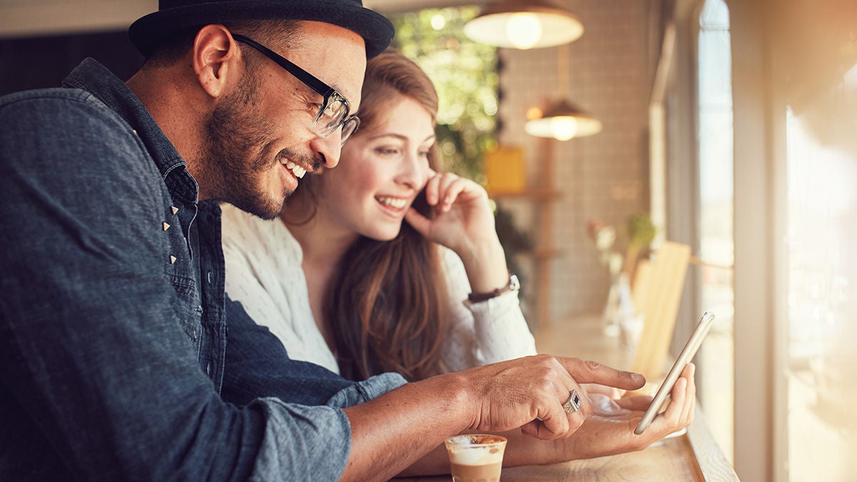Couple using smart phone at coffee shop