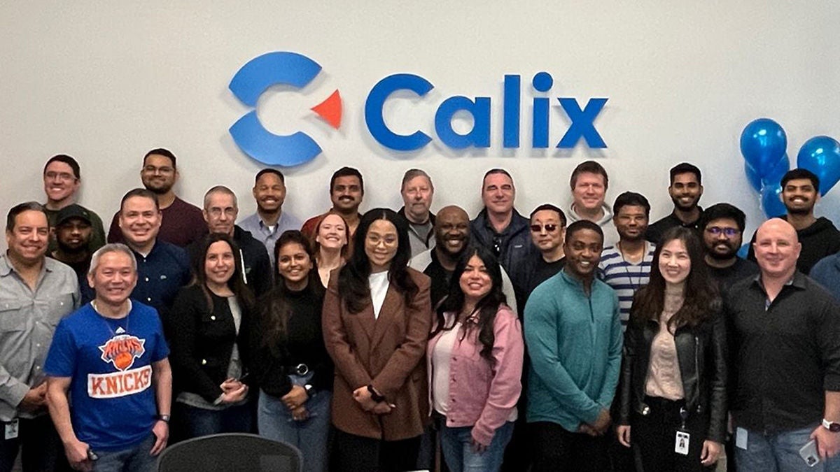 Calix employees smiling with Calix logo