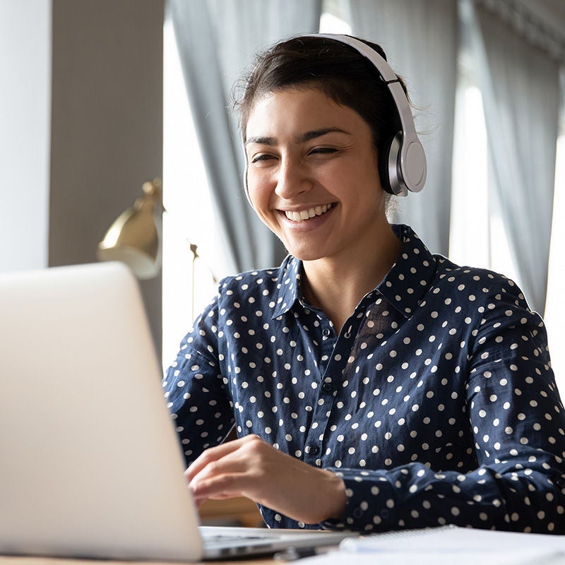 smiling woman with laptop and headphones
