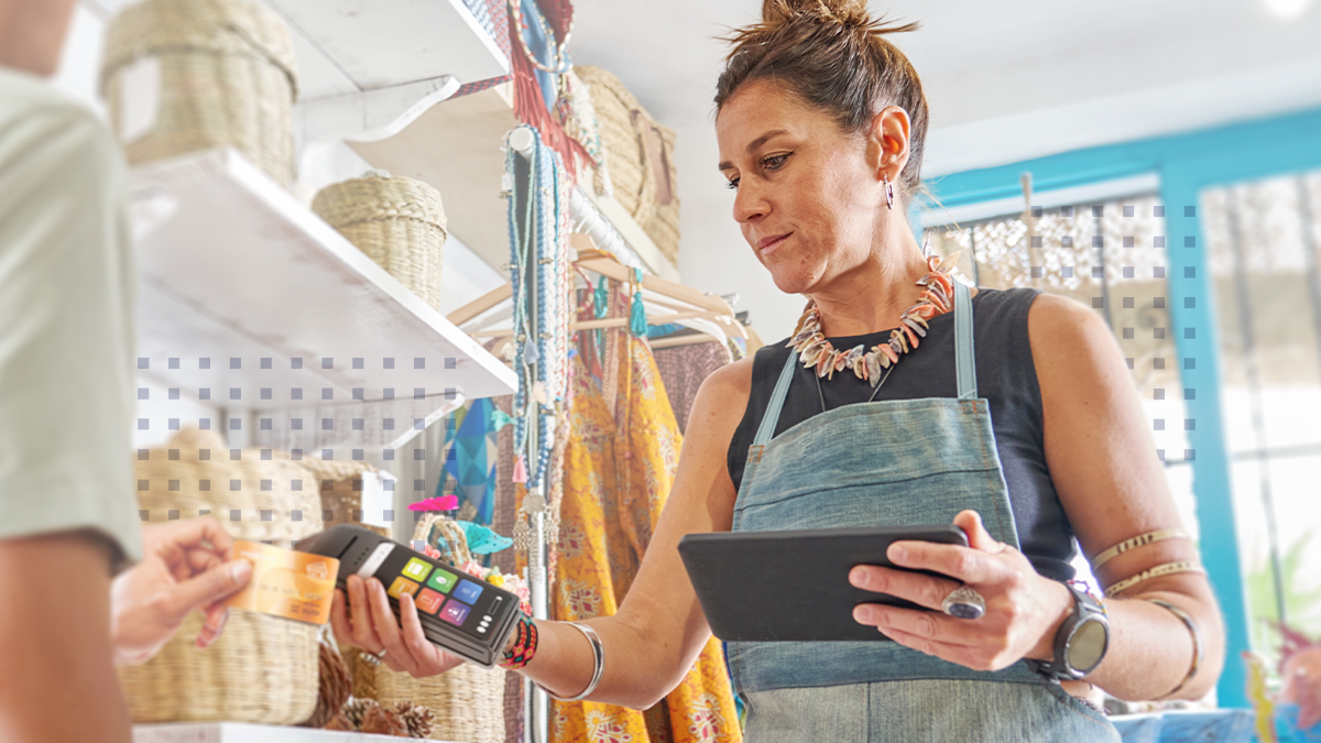 female small business owner checking out a customer with a tablet and credit card machine