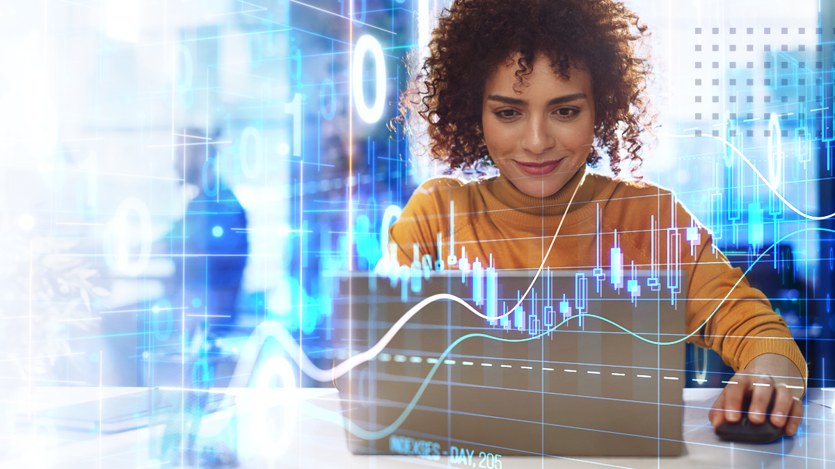 A business woman analyzing stock graphs, charts working on the laptop with blurred office background