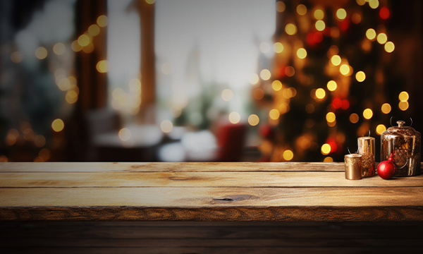 Empty wooden table with christmas decorations in front of a blurred background