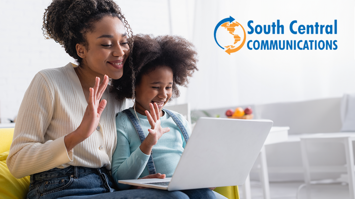 smiling mother and daughter on video call over laptop