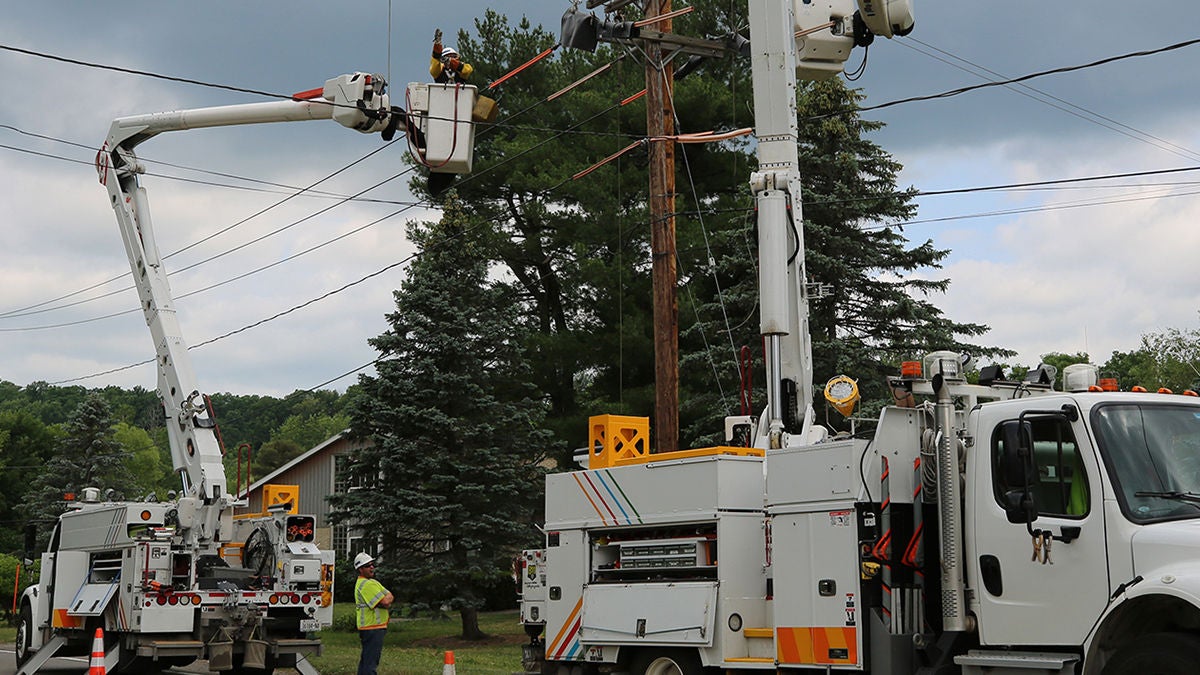 seneca-energy-telecom-powerline-workers-16-9 Two large work trucks with workers in each man lifter working on a power line