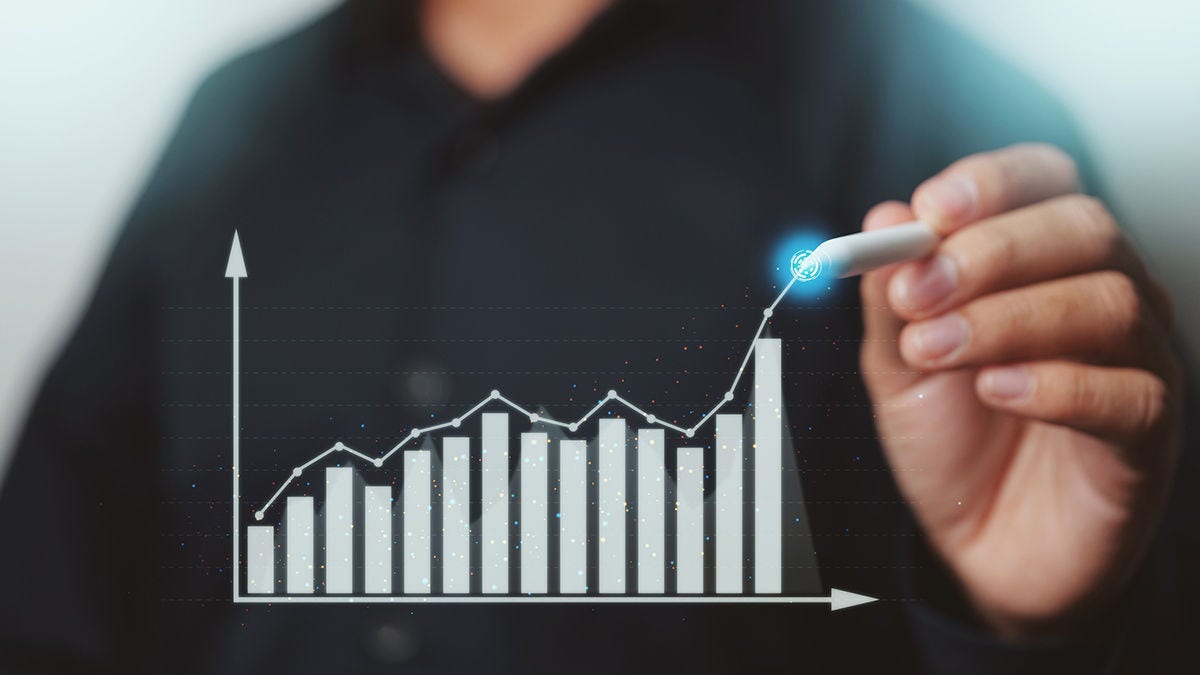 A man holding a pen drawing lines on an abstract graph
