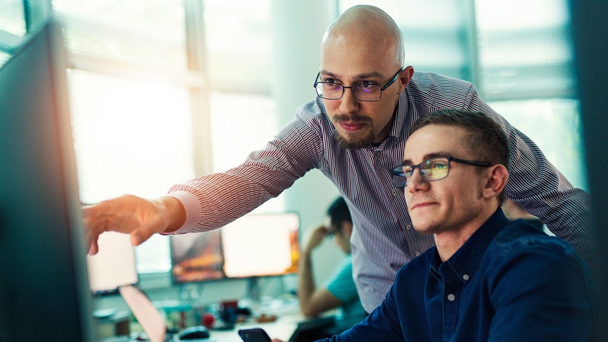 Two coworkers working together on computer