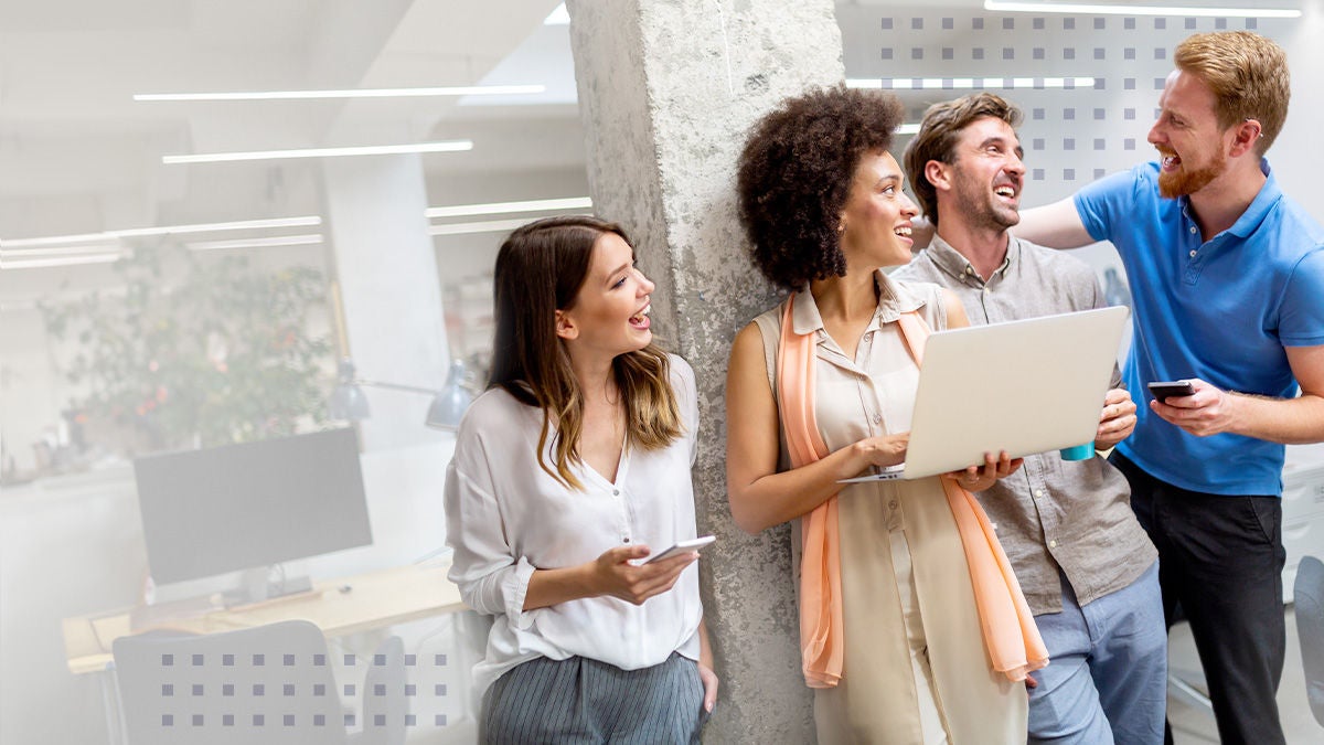 A group of happy colleagues reviewing NPS questions on a laptop