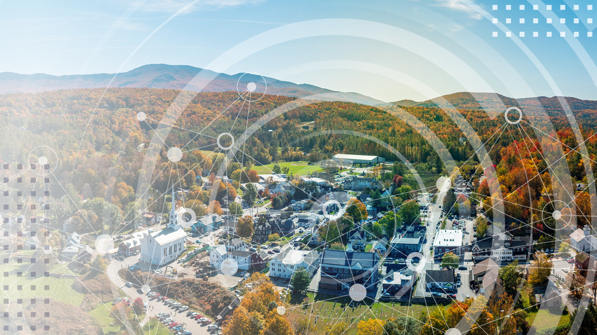 An aerial view of a small rural town covered in abstract Wi-Fi rings and connected network symbols