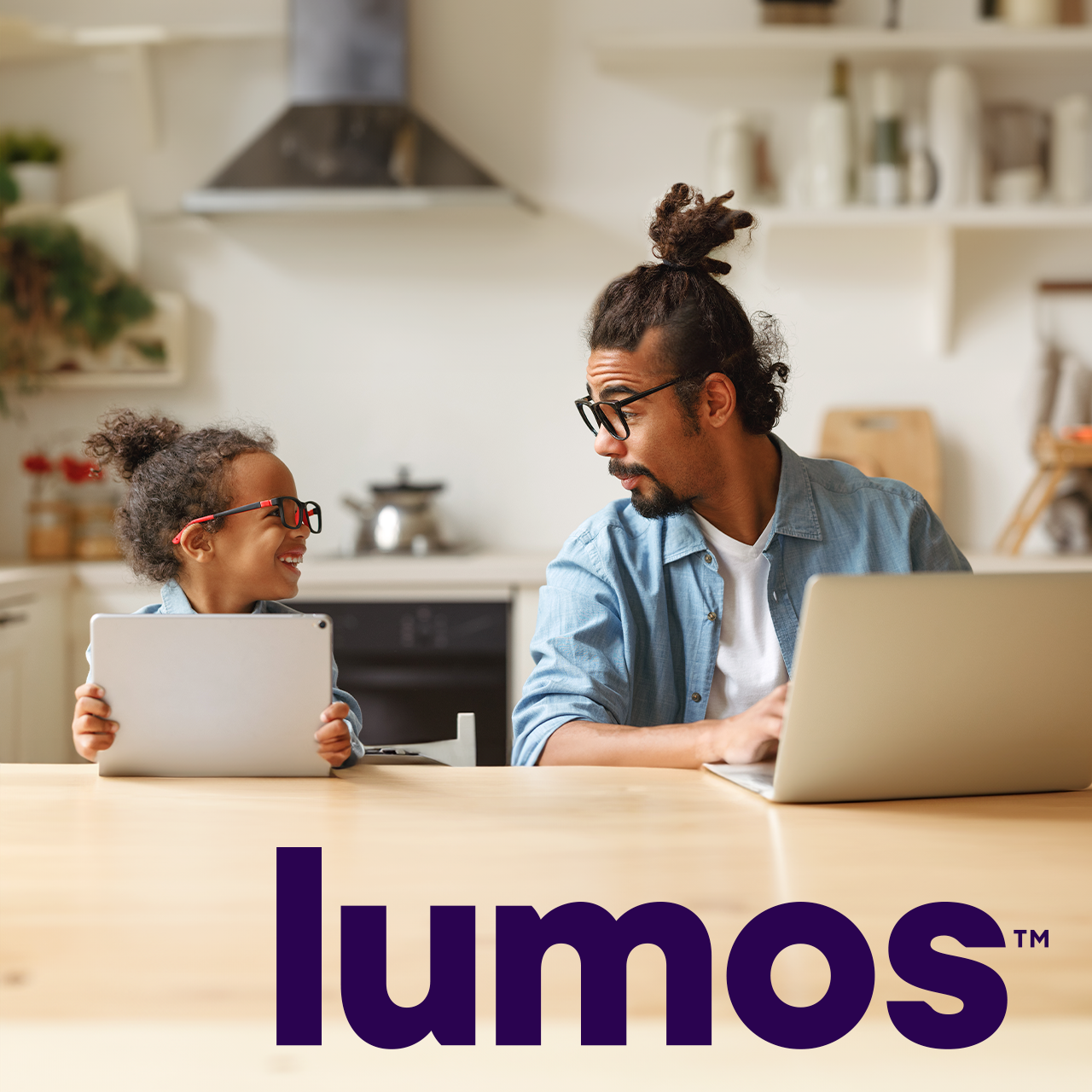 Father and son playing on devices in kitchen