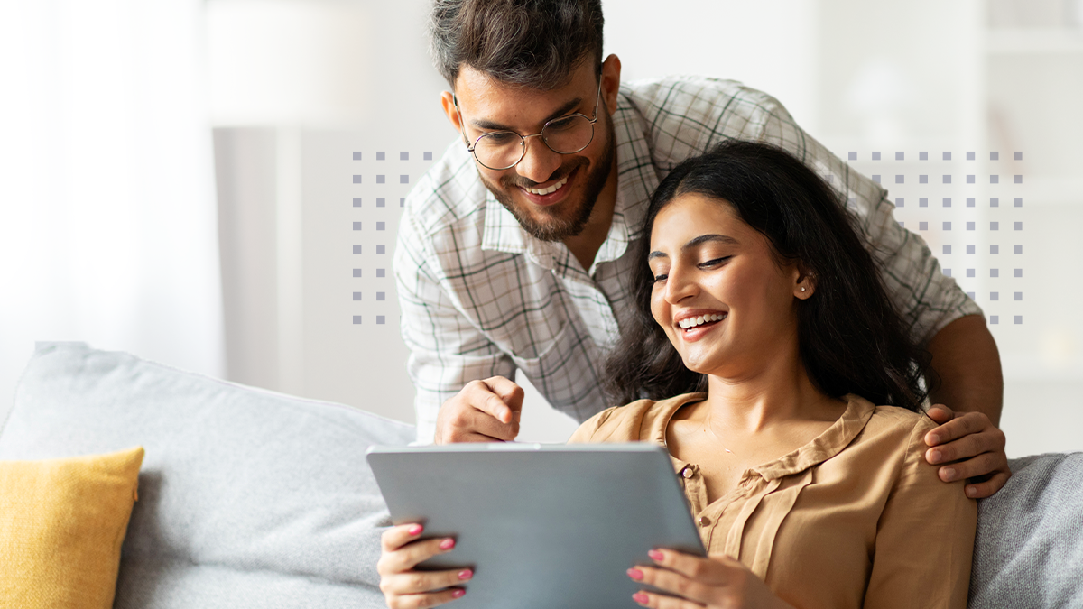Happy husband and wife viewing a tablet