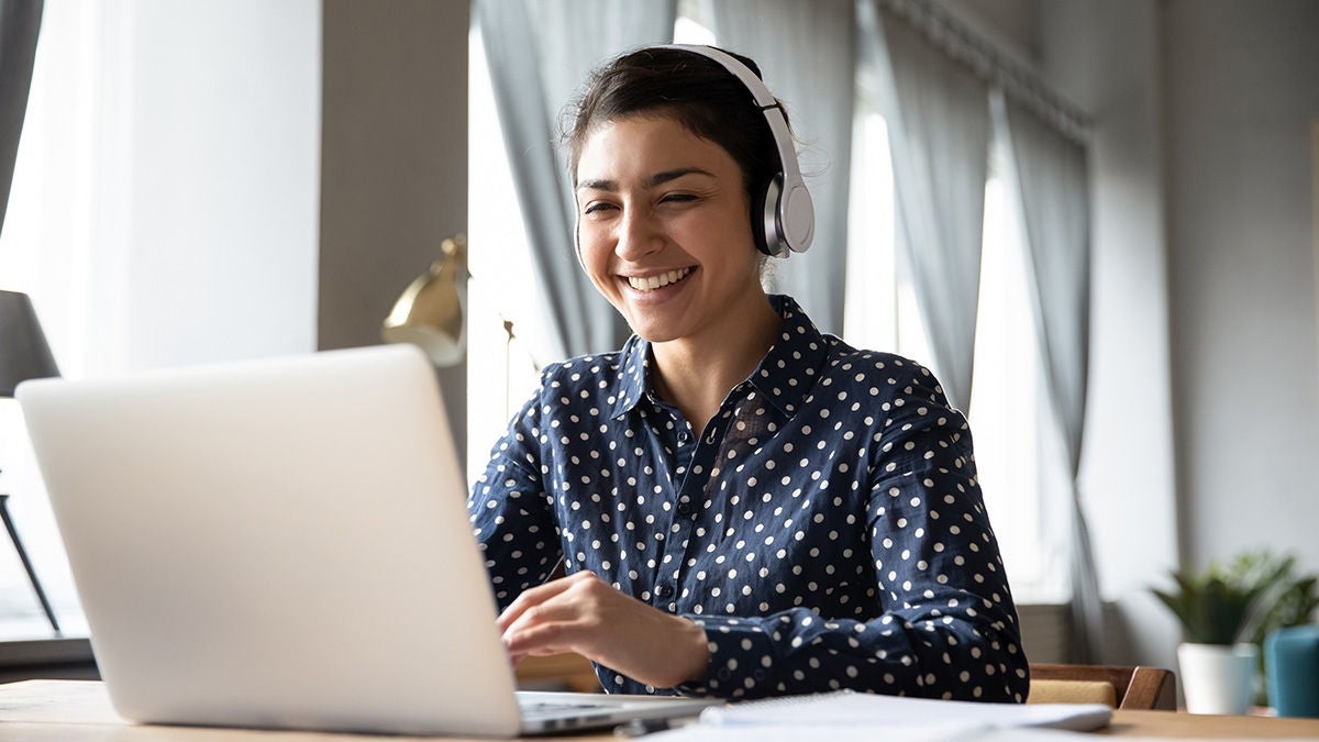 smiling woman with laptop and headphones