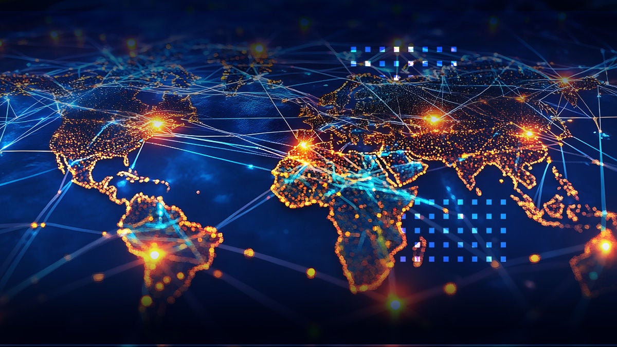 A stylized world map is illuminated with glowing points and connecting lines, representing a global digital network. The image uses a dark blue palette with bright orange and blue highlights to indicate major hubs and data flows. Abstract grid elements and light flares enhance the sense of advanced technology and connectivity. No visible text or numbers are present in the image.