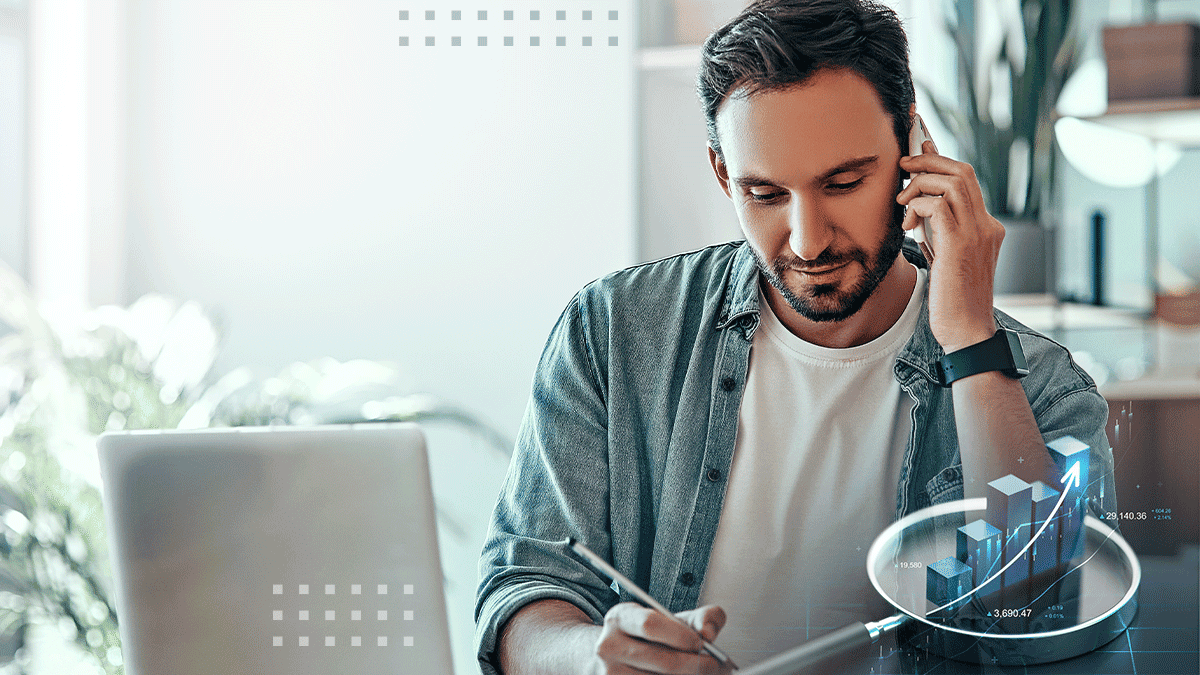 Young business professional talking on the mobile phone and using a digital pen on the tablet and working on the financial charts 