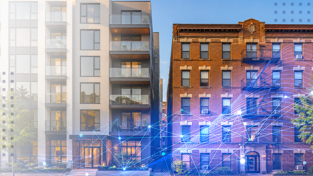 The image shows a modern glass-front apartment building beside an older brick residential structure