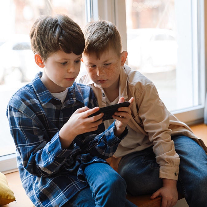 Two boys viewing a cell phone
