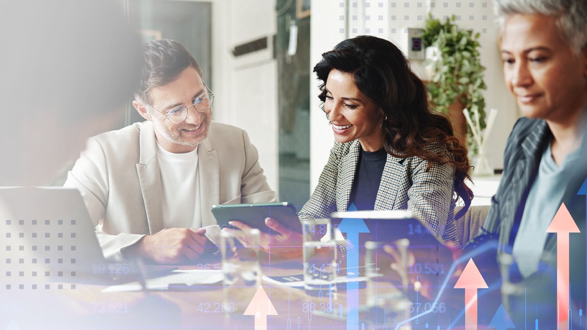 Shot of business people holding a digital tablets and working on laptop while speaking to a colleagues during a meeting at work