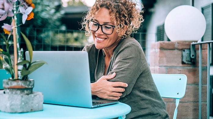 smiling woman on laptop outdoors