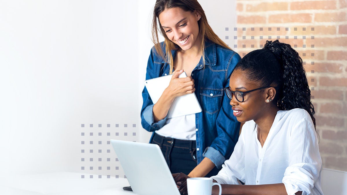 Two employees using operations excellence to accelerate growth on a laptop