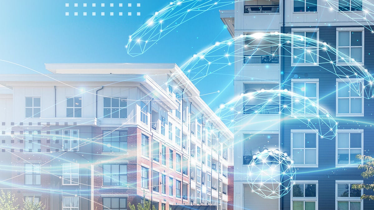 Modern mid-rise apartment buildings are shown under a clear blue sky with a digital network overlay. Glowing lines and geometric nodes arc between the structures, suggesting wireless connectivity and data exchange. The scene blends real architecture with abstract technology graphics to convey smart city infrastructure. Bright lighting and cool tones create a clean, futuristic atmosphere focused on innovation in urban living.