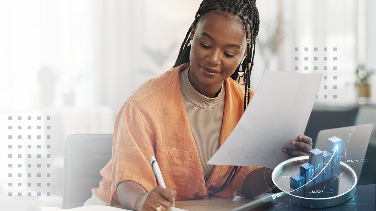 Focused young businesswoman analyzing financial reports at a modern workspace with a laptop and office supplies