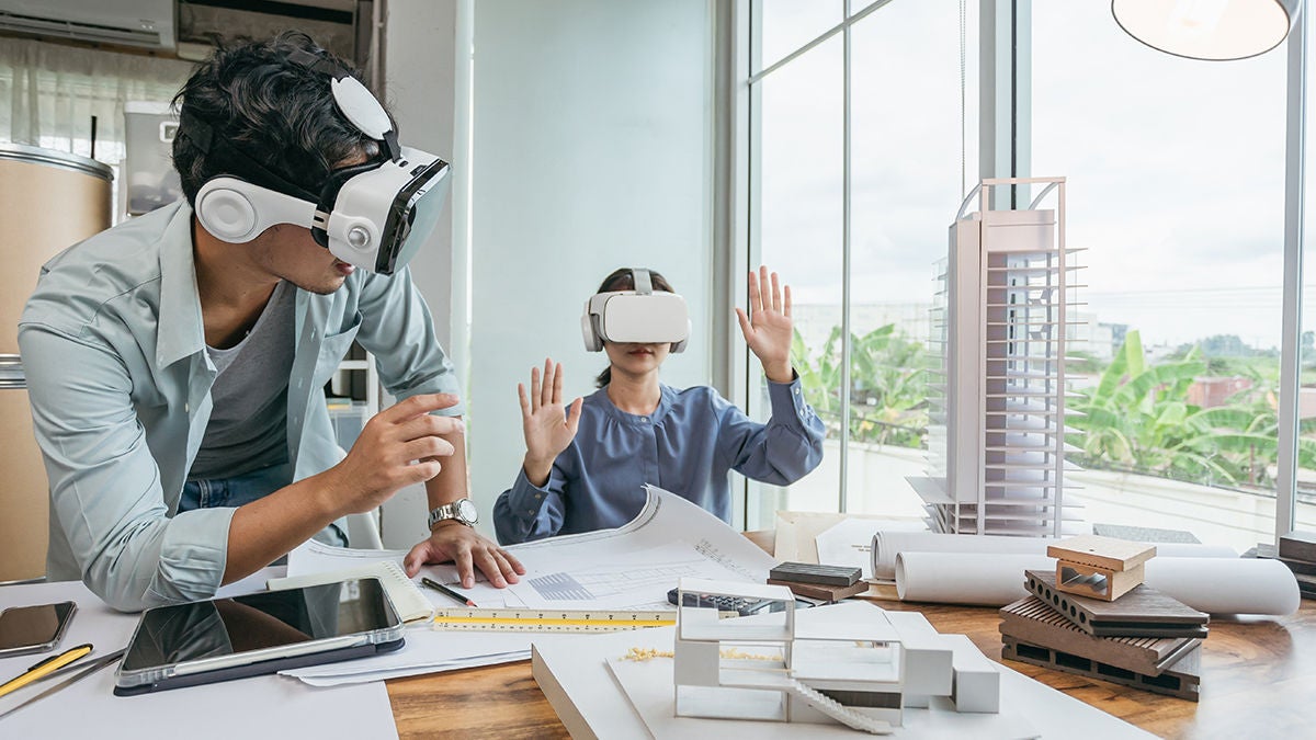 Two coworkers wearing AR goggles while viewing architecture projects