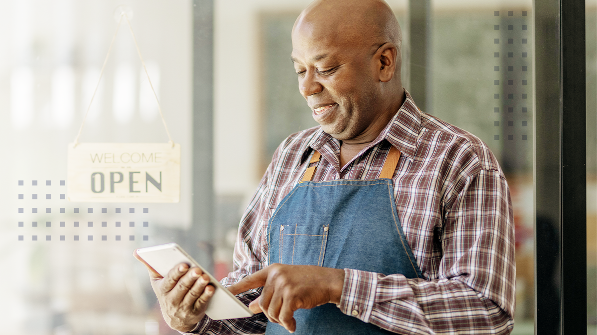 A smiling small business owner utilizing SmartBiz and CommandWorx on a tablet