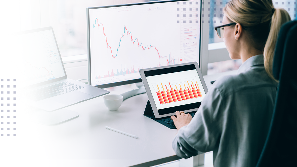 A woman on a computer and tablet viewing broadband data and analytics