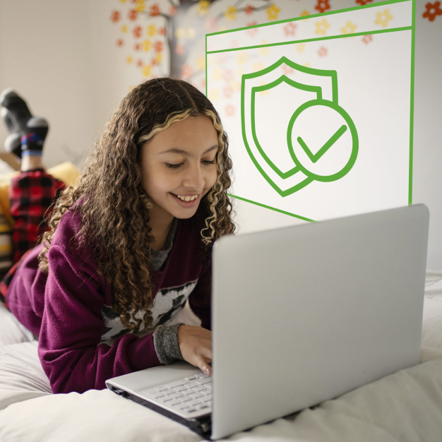 Young smiling girl working on laptop at home