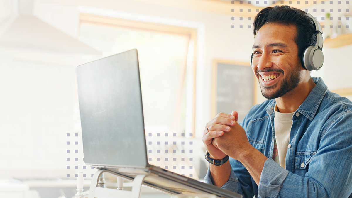 A man smiling at his laptop using a simplified broadband network