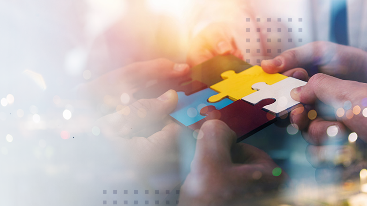 Several hands work together to connect colorful puzzle pieces, symbolizing collaboration and problem solving