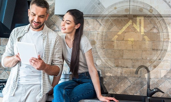 smiling couple using digital tablet together in kitchen, smart home concept
