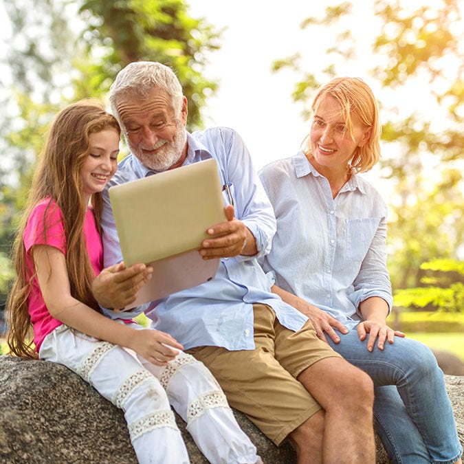 smiling family with laptop in park