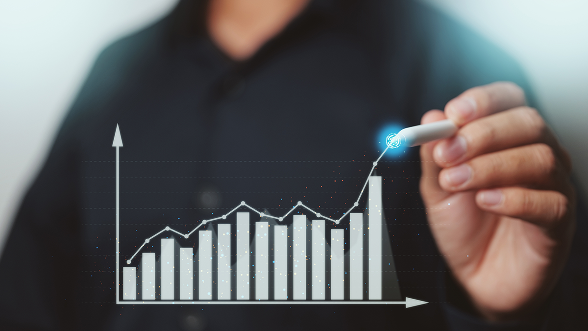 A man holding a pen drawing lines on an abstract graph