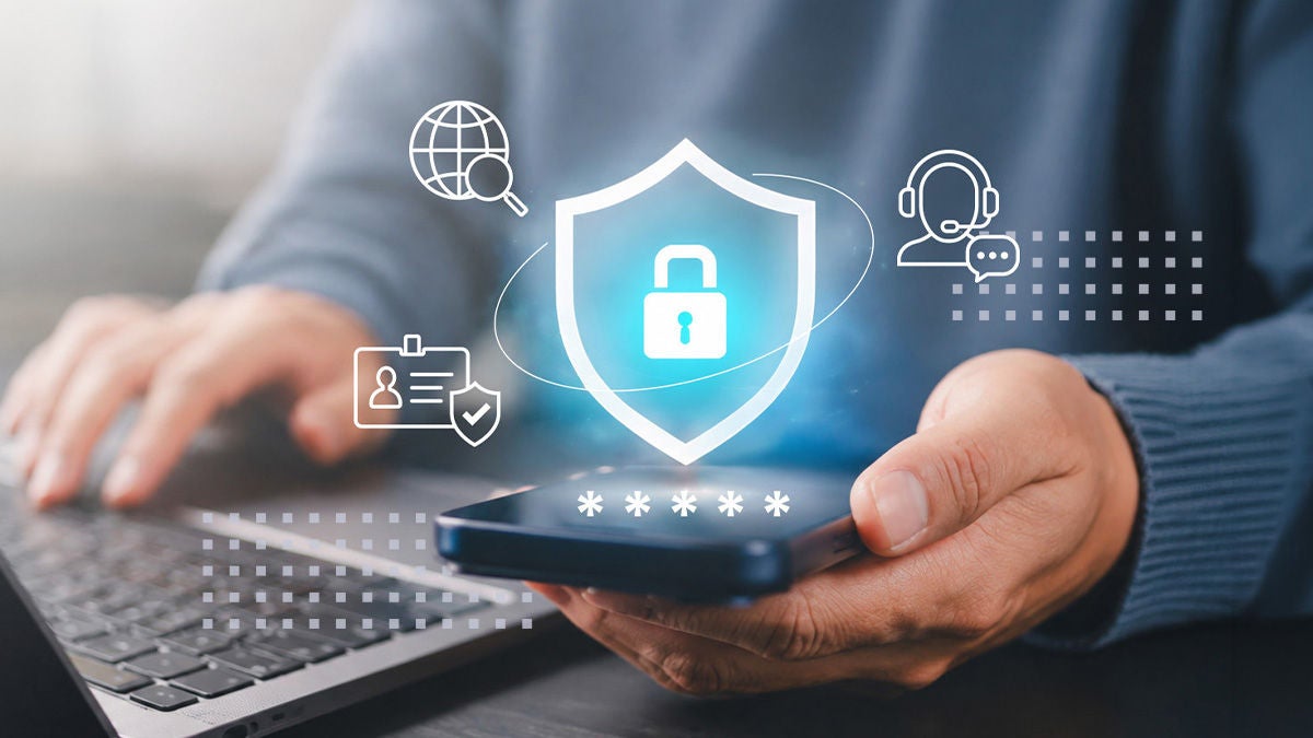 A person holds a smartphone in front of a laptop, with a glowing shield icon featuring a padlock symbolizing data security and privacy. Abstract digital icons around the shield suggest global connectivity, user identity, and customer support. The scene conveys modern cybersecurity concepts such as secure access, encryption, and safe online communication. Soft blue tones and bokeh light effects create a professional, trustworthy atmosphere.