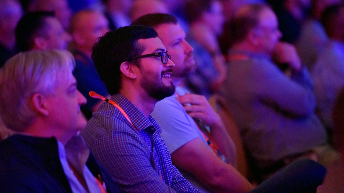 enthusiastic attendees attending a speaker event, sitting in a crowded hall