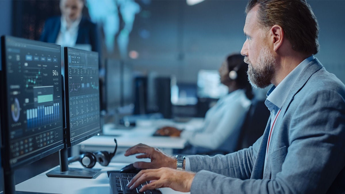 man monitoring computer screens