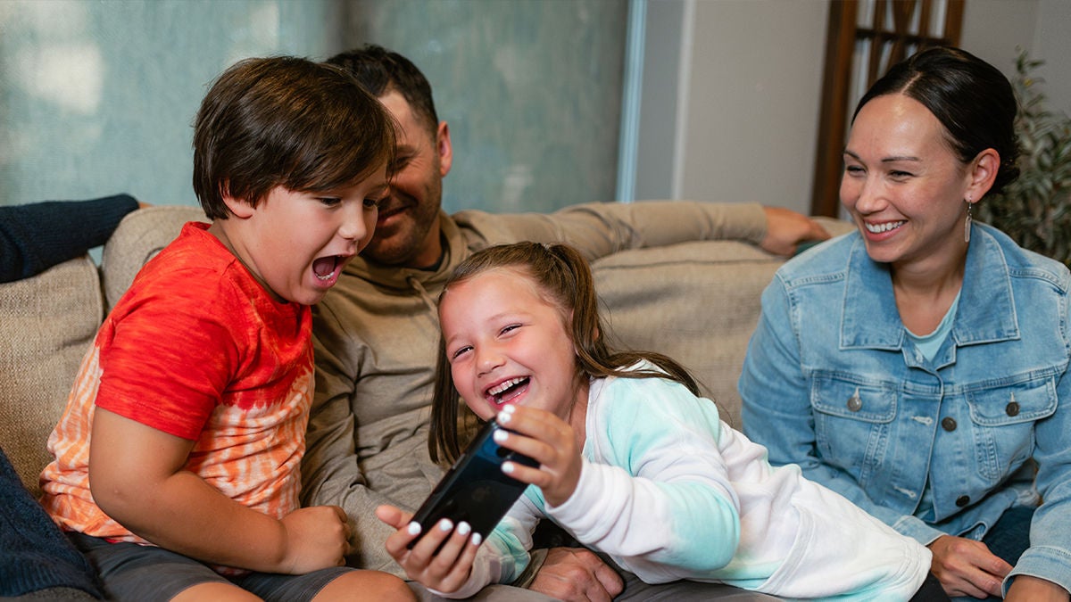 A happy family looking at a cell phone
