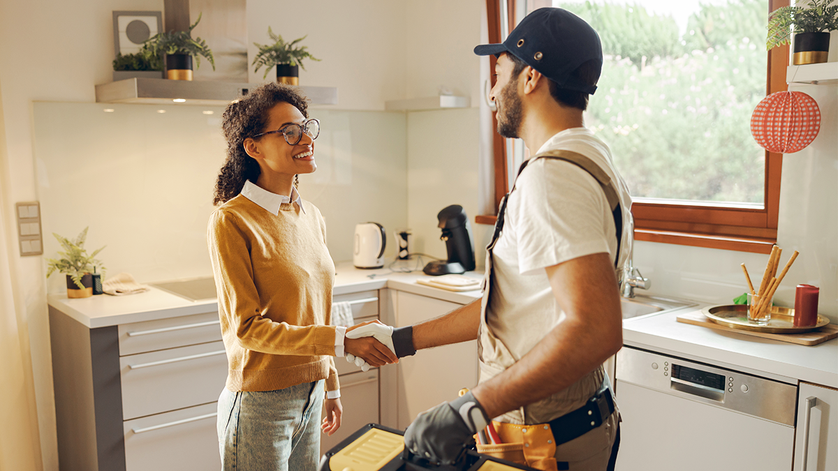 Technician in home Technician shakes woman's hand in home doing service