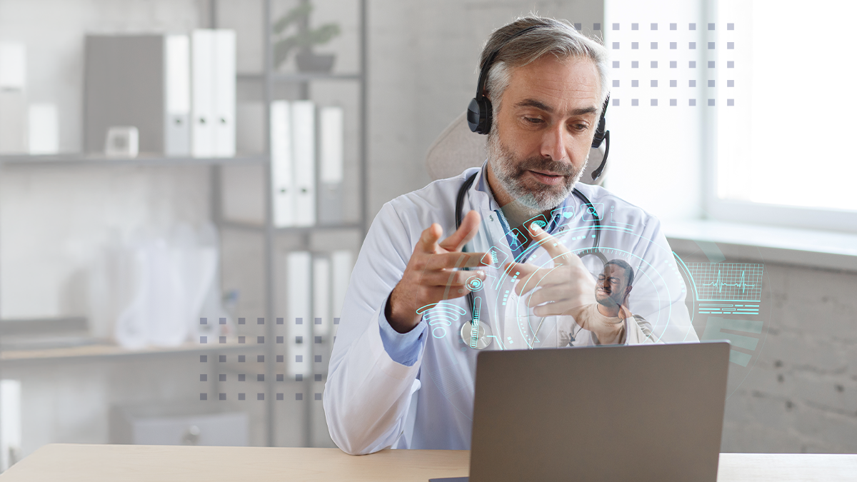 Senior male doctor in his office using laptop for video chat with a patient. Online consultation with doctor for diagnoses and treatment recommendation.