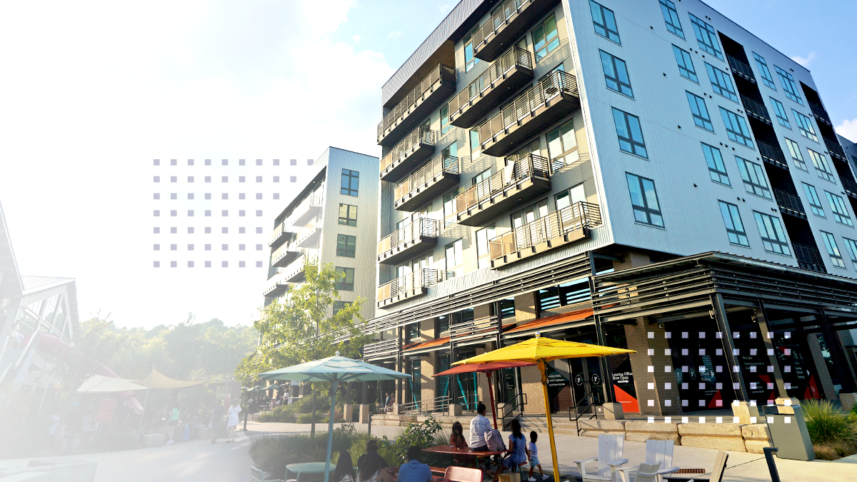 A contemporary multi-story apartment building features balconies and large windows, set in an urban environment