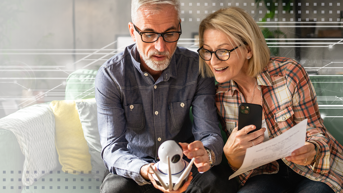 Couple at home mature or senior caucasian husband and wife connect and install cctv security surveillance camera