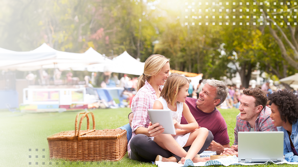 Happy family relaxing and enjoying a picnic together at  park outdoor summer event
